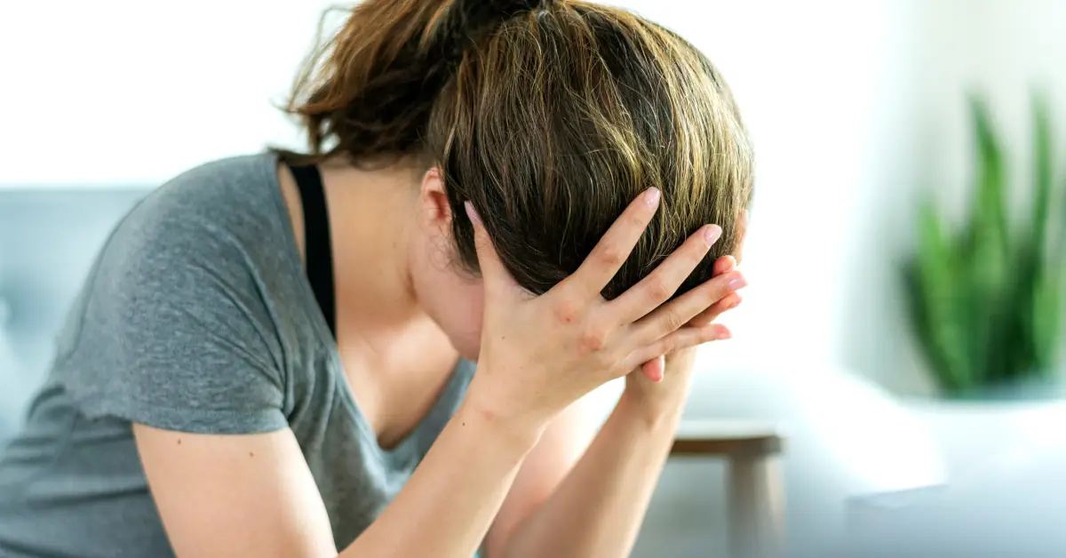 stressed woman with head resting in hands